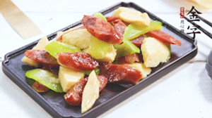 熱油下鍋，依次下金字香腸、萵筍、冬筍，均勻翻炒。