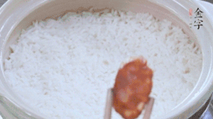 煮開后轉(zhuǎn)小火，當(dāng)米飯出現(xiàn)小孔時，鋪上金字麻辣香腸。