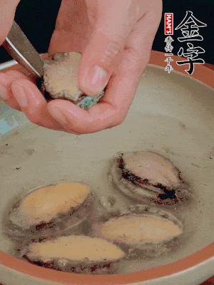 鮑魚加鹽、清水浸泡，用勺子挖出鮑魚肉。
