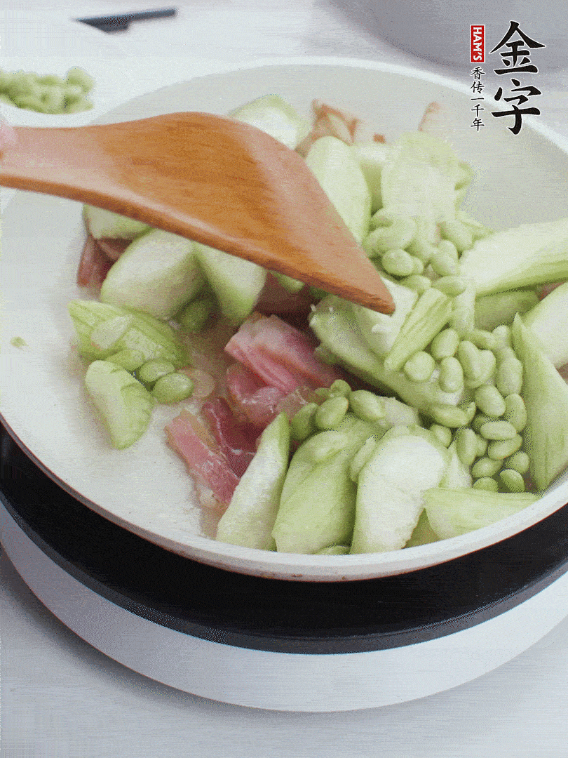 依次下絲瓜、青豆翻炒，炒至絲瓜打蔫縮小。