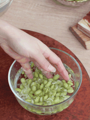 青豆剝殼，搓去外衣。